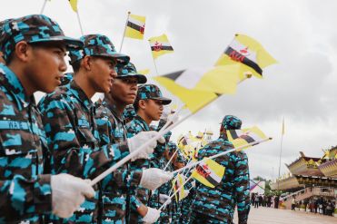 Youth from the National Service Program (PKBN) waving the Brunei flag during the national day celebration. Photo: Hazimul Wa'ie/The Scoop