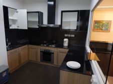 Apartment kitchen is complete with electric stove, microwave, refrigerator and water boiler. Photo: The Scoop