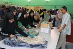 Volunteers fold clothes at the check out point for the Raya Donation Drive Photo: Rasidah Hj Abu Bakar/The Scoop