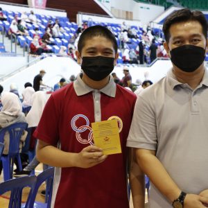 12-year-old Md Sabil pose swith his father, Azrin Yahaya, after getting a COVID jab at Indoor Stadium. Photo: Rudolf Portillo/The Scoop